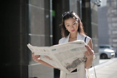 Businesswoman looks at a newspaper