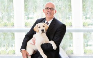 Titus Herman, CEO, holds a puppy
