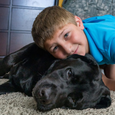 Talon and Gold Star Family Dog Hope lying on the floor, cuddling together.