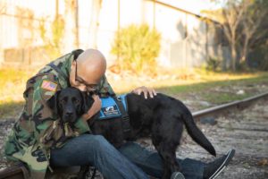 A photo of Sean Brown hugging his service dog Nick