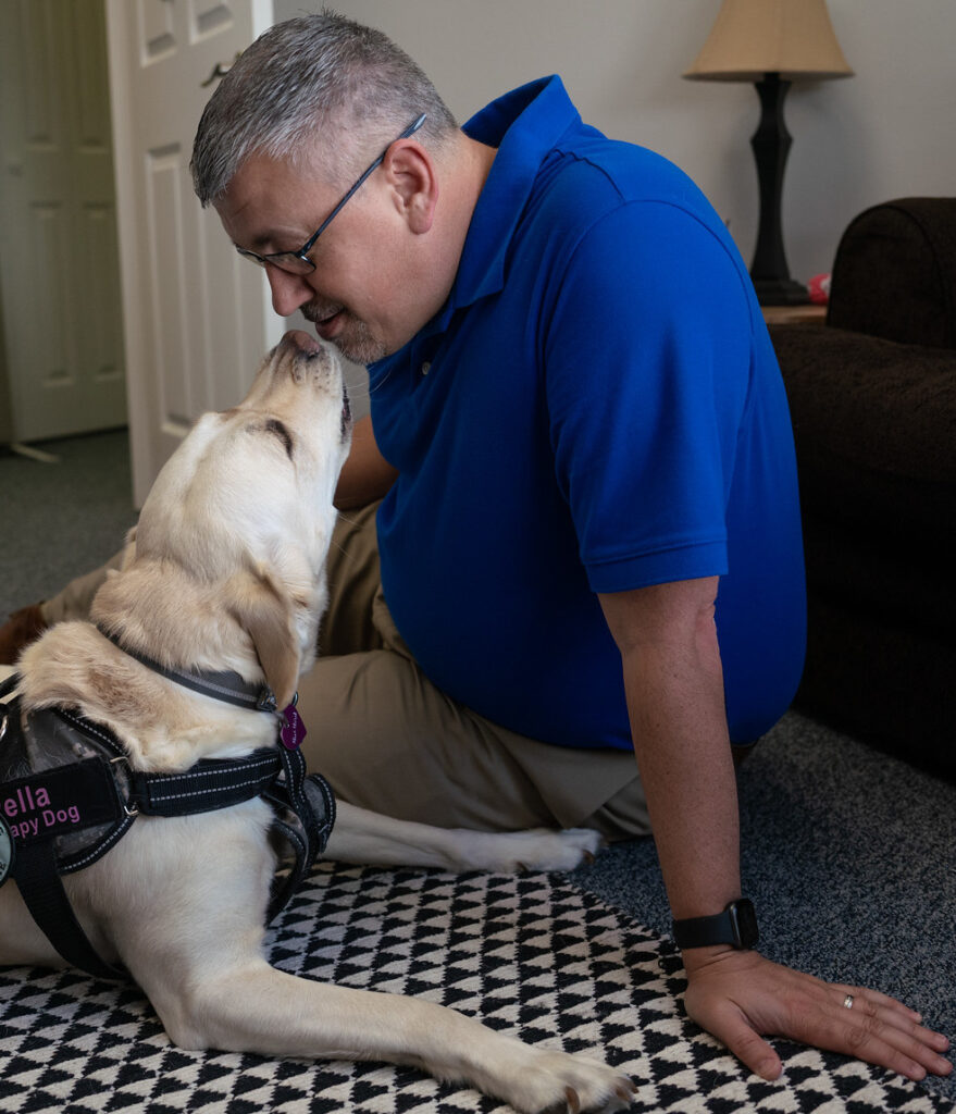 A photo of Robert Reuille with Facility Therapy Dog Pella