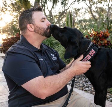 A photo of Travis Johnson with Service Dog Sadie