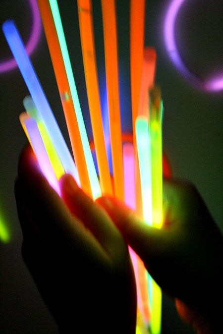 Kids playing with glow sticks at night.